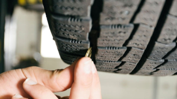 Image showing how you can easily measure your tyre tread depth with a coin to see if it legal or illegal in the UK