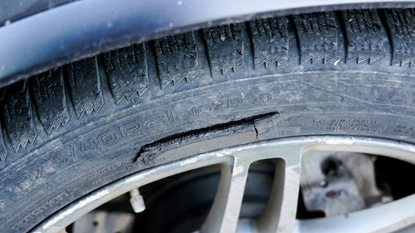 Image showing a cracked and damaged car tyre sidewall which is illegal in the UK and would need immediate replacement
